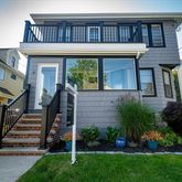a view of a house with a small yard plants and large tree