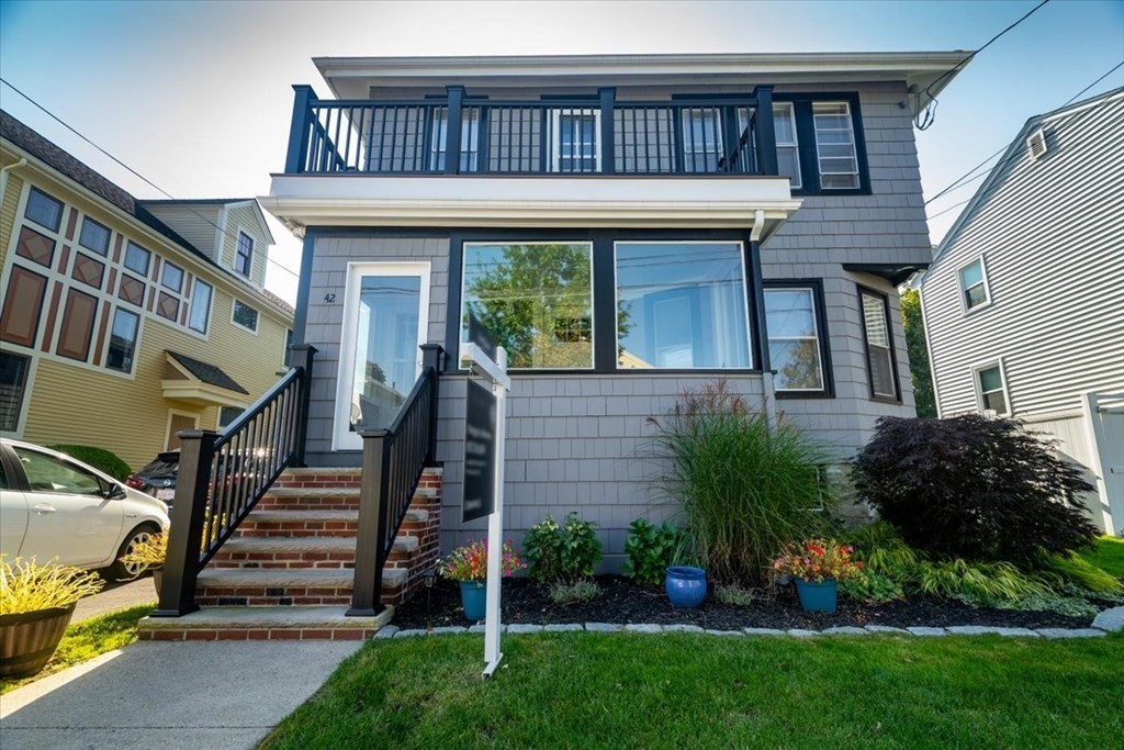 a view of a house with a small yard plants and large tree