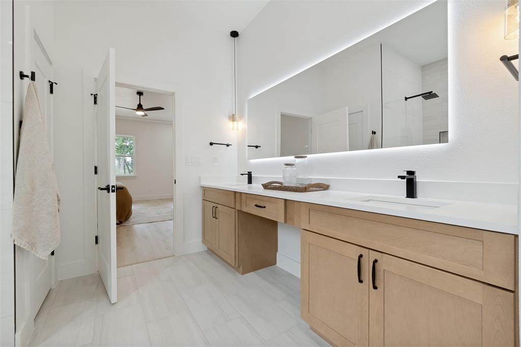 1143 Riverwood Road Dallas, TX 75217 - Photo 24 of 24 Contemporary bathroom featuring a double vanity with light wood cabinetry, white countertops, and matte black fixtures