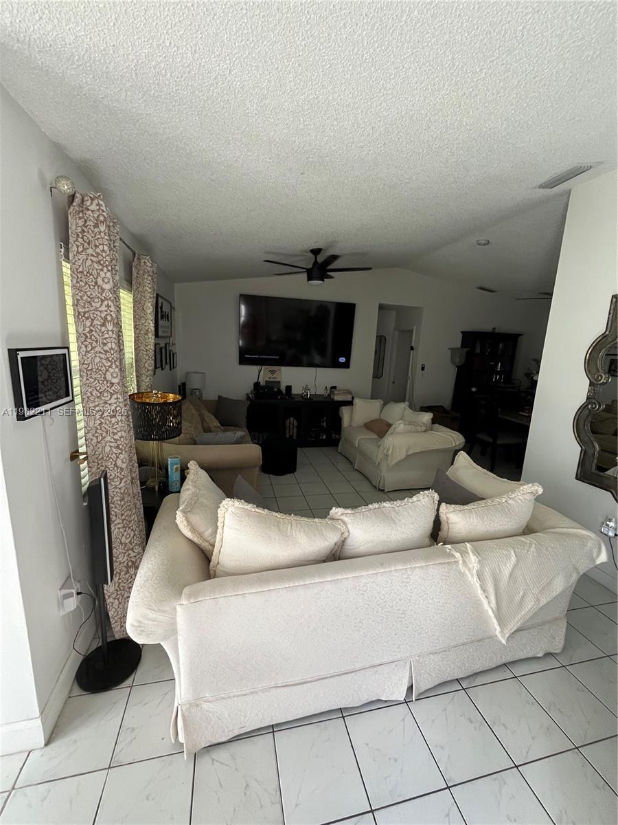 13485 Southwest 28th Street Miami, FL 33175 - Photo 6 of 33 a living room with furniture a fireplace and a flat screen tv