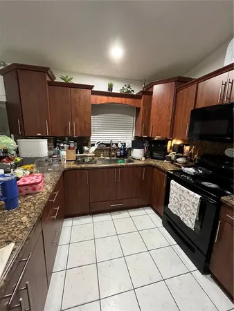 a kitchen with a sink a stove and cabinets