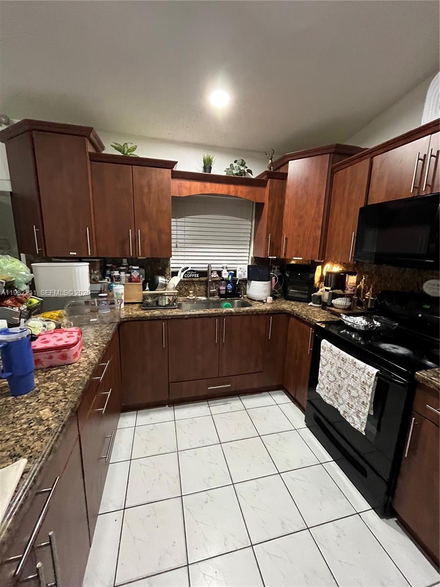 13485 Southwest 28th Street Miami, FL 33175 - Photo 10 of 33 a kitchen with a sink a stove and cabinets