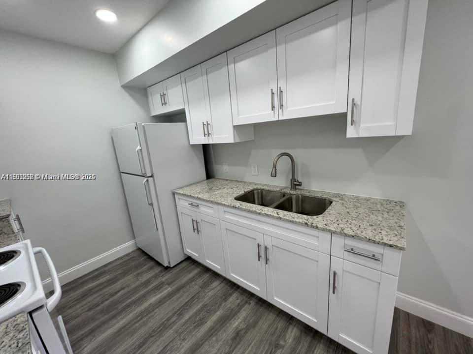 245 Northeast 191st Street, Unit 3014 Miami, FL 33179 - Photo 2 of 8 a kitchen with sink a cabinets and appliances