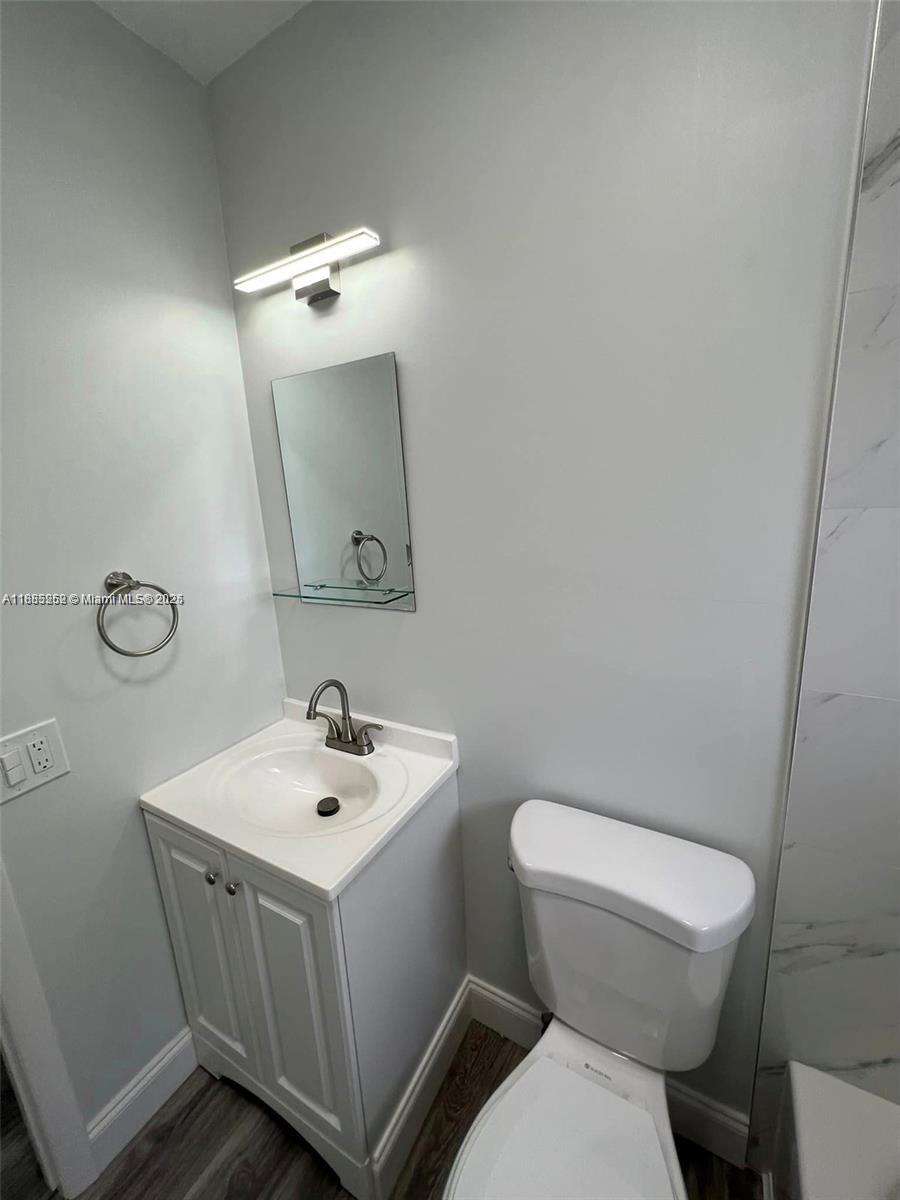245 Northeast 191st Street, Unit 3014 Miami, FL 33179 - Photo 7 of 8 a white toilet sitting next to a bathroom sink