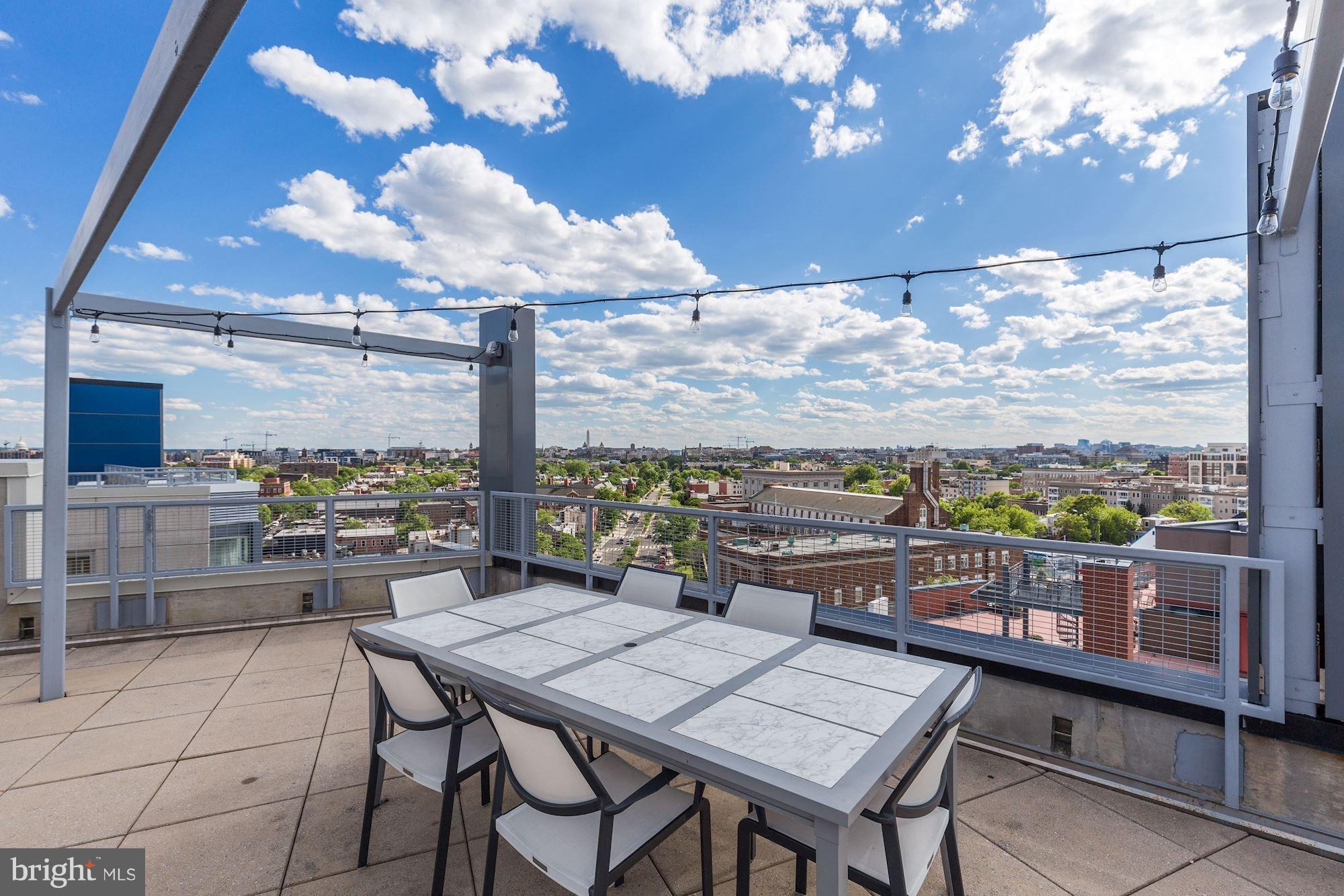 929 Florida Avenue Northwest, Unit 4002 Washington, DC 20001 - Photo 11 of 12 a view of a balcony with table and chairs and wooden floor
