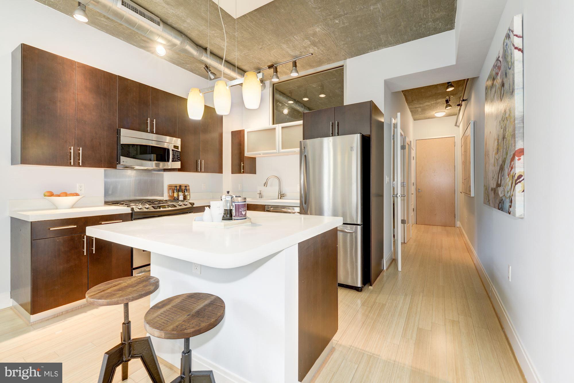 929 Florida Avenue Northwest, Unit 4002 Washington, DC 20001 - Photo 4 of 12 a kitchen with stainless steel appliances a refrigerator and a stove top oven