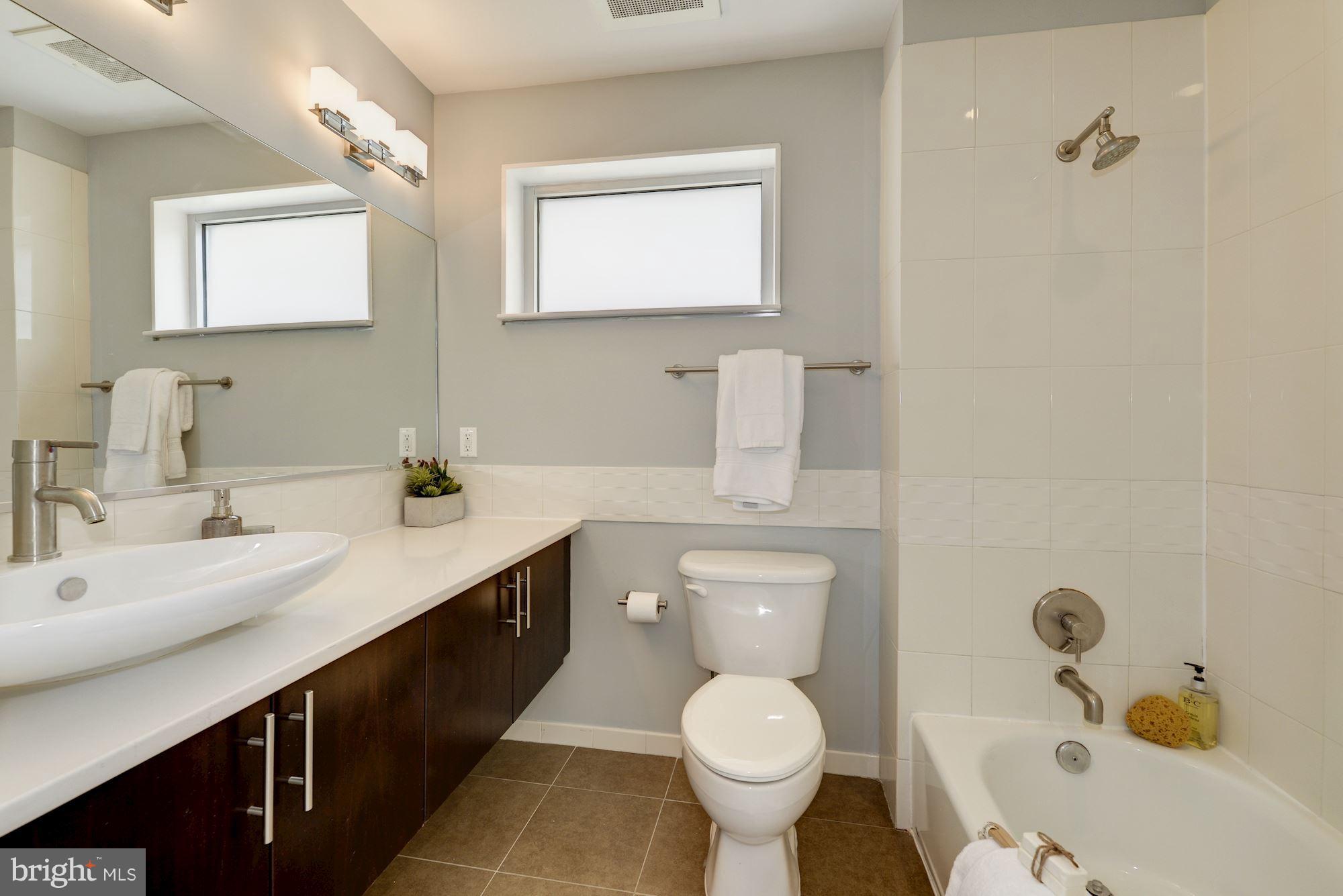 929 Florida Avenue Northwest, Unit 4002 Washington, DC 20001 - Photo 6 of 12 a bathroom with a granite countertop sink mirror vanity and toilet