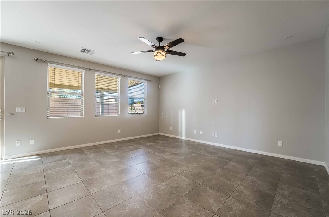 55 Canopus Ridge Way Las Vegas, NV 89183 - Photo 3 of 26 An inviting room features neutral walls, cool tile flooring, and ample natural illumination.