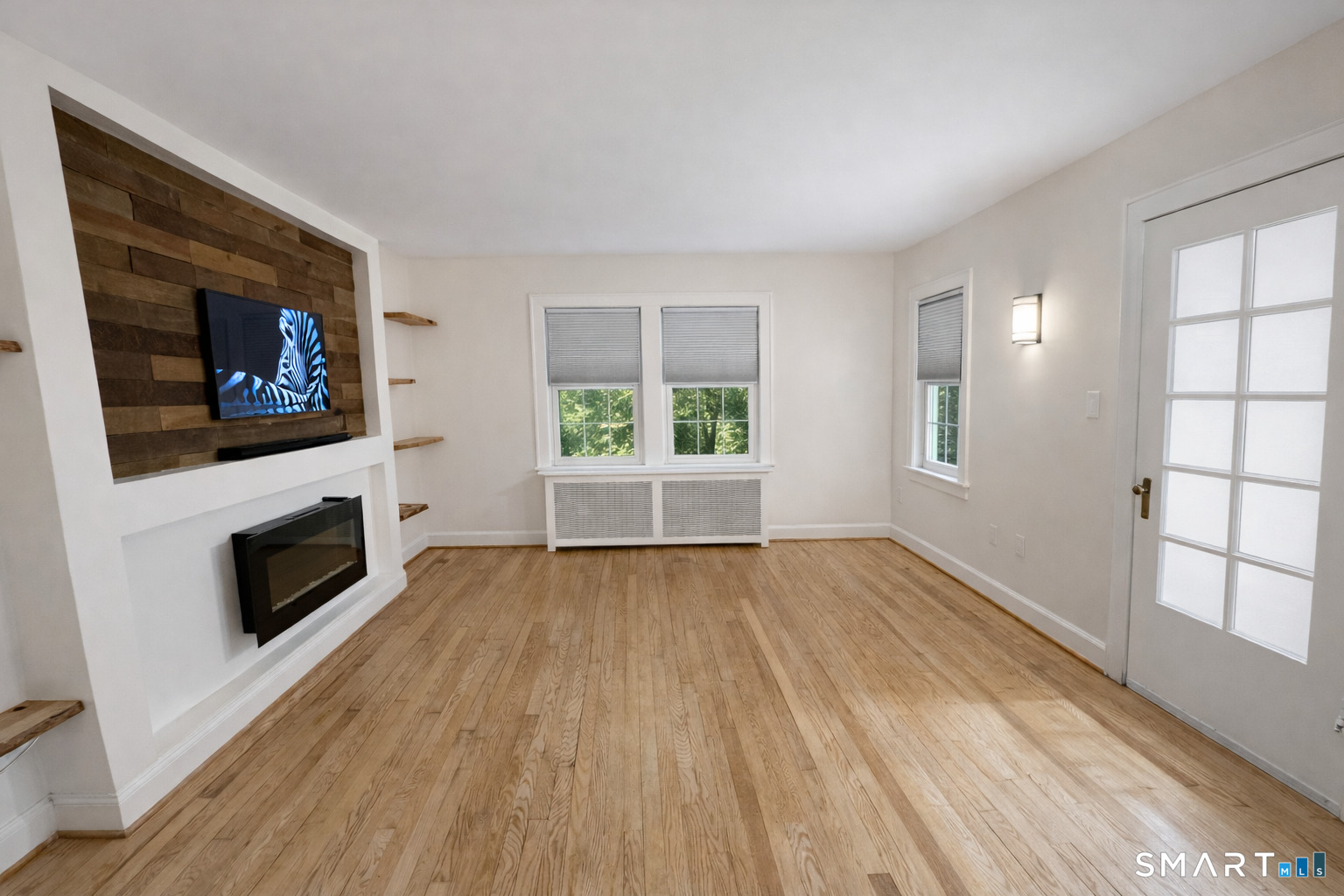 483 Charles Street Torrington, CT 06790 - Photo 6 of 40 a view of an empty room with a fireplace and a window