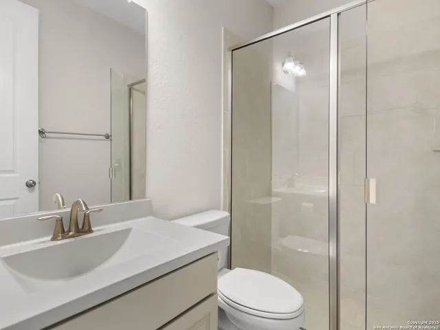 a bathroom with a sink toilet vanity and shower