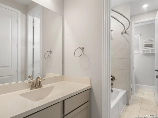 a bathroom with a sink double vanity granite tub shower and a mirror
