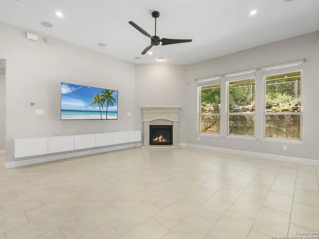 a view of an empty room with a fireplace and a window