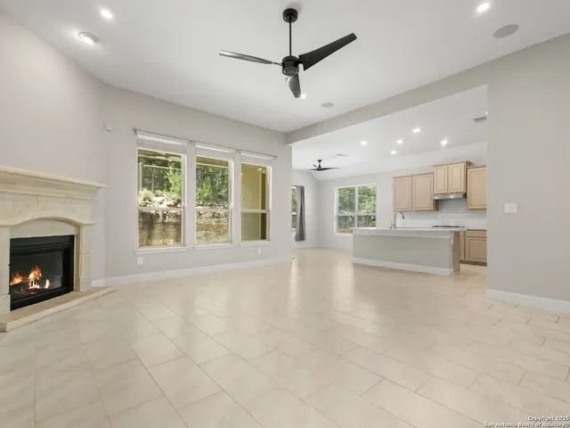 a view of an empty room with a fireplace and a window