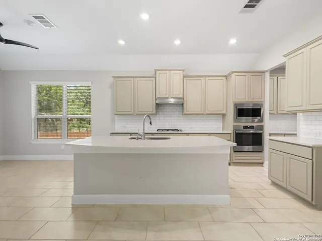 a large kitchen with stainless steel appliances granite countertop a stove and a sink