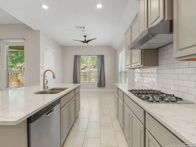 a kitchen with stainless steel appliances granite countertop a sink stove and cabinets