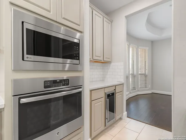 a kitchen with granite countertop white cabinets and stainless steel appliances