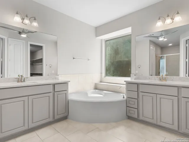 a bathroom with a double vanity sink a mirror and a bathtub