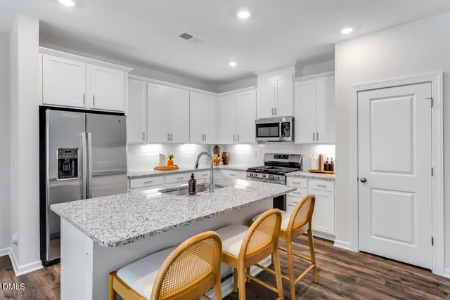 a white bath tub sitting next to a white sink and vanity