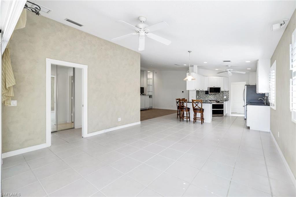 3025 Futuna Lane Naples, FL 34119 - Photo 12 of 46 Living area featuring light tile patterned floors and a ceiling fan