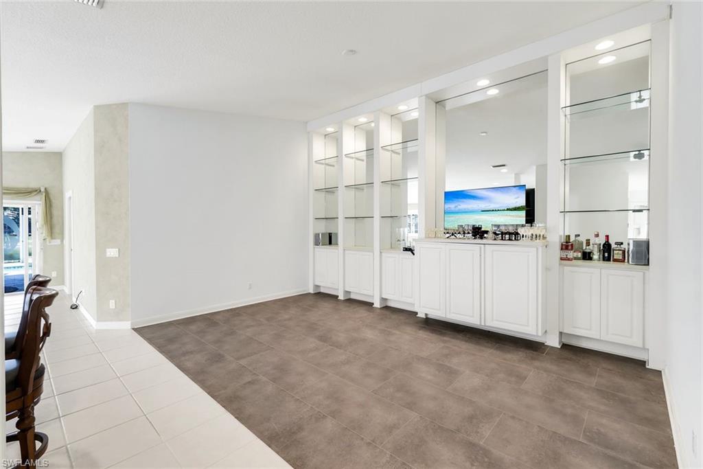 3025 Futuna Lane Naples, FL 34119 - Photo 13 of 46 Unfurnished living room featuring light tile patterned floors and built in features
