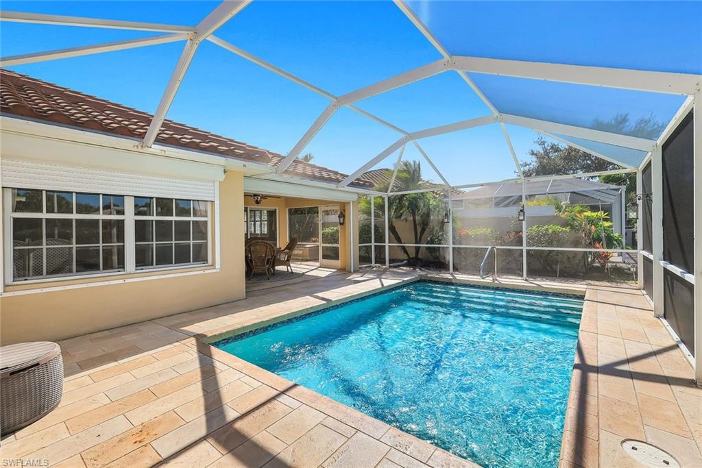 3025 Futuna Lane Naples, FL 34119 - Photo 7 of 46 View of pool featuring a sunroom, glass enclosure, and patio surround