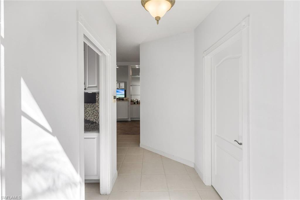 3025 Futuna Lane Naples, FL 34119 - Photo 9 of 46 Corridor with baseboards and light tile patterned flooring