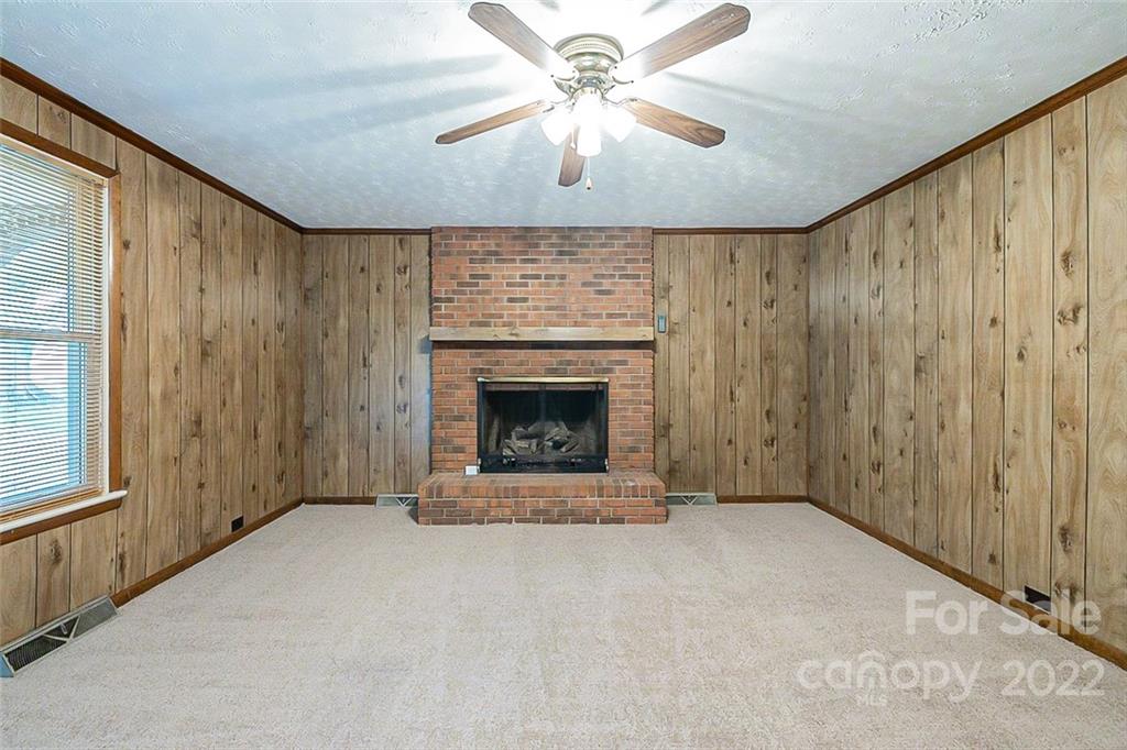 621 Rowan Mill Road Salisbury, NC 28147 - Photo 3 of 13 a view of an empty room with a fireplace and a window
