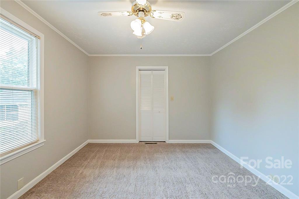 621 Rowan Mill Road Salisbury, NC 28147 - Photo 7 of 13 an empty room with a chandelier fan and windows