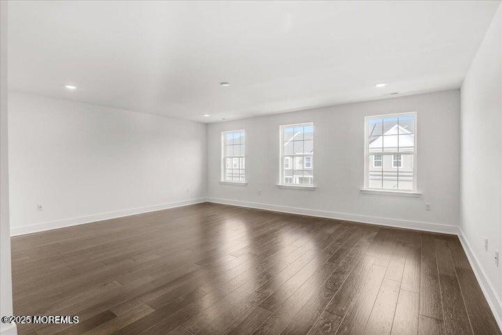 179 Woolley Court, Unit 1 Asbury Park, NJ 07712 - Photo 18 of 24 an empty room with wooden floor and windows