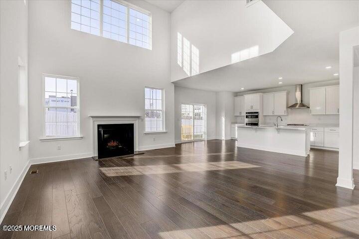 179 Woolley Court, Unit 1 Asbury Park, NJ 07712 - Photo 4 of 24 a view of empty room with wooden floor and fireplace