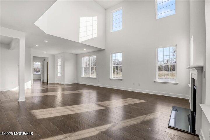 179 Woolley Court, Unit 1 Asbury Park, NJ 07712 - Photo 6 of 24 a view of an empty room with wooden floor and a window