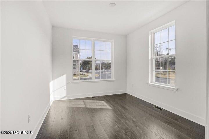 179 Woolley Court, Unit 1 Asbury Park, NJ 07712 - Photo 10 of 24 an empty room with wooden floor and windows