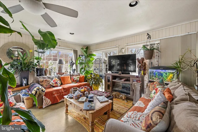 a living room with patio furniture and a flat screen tv