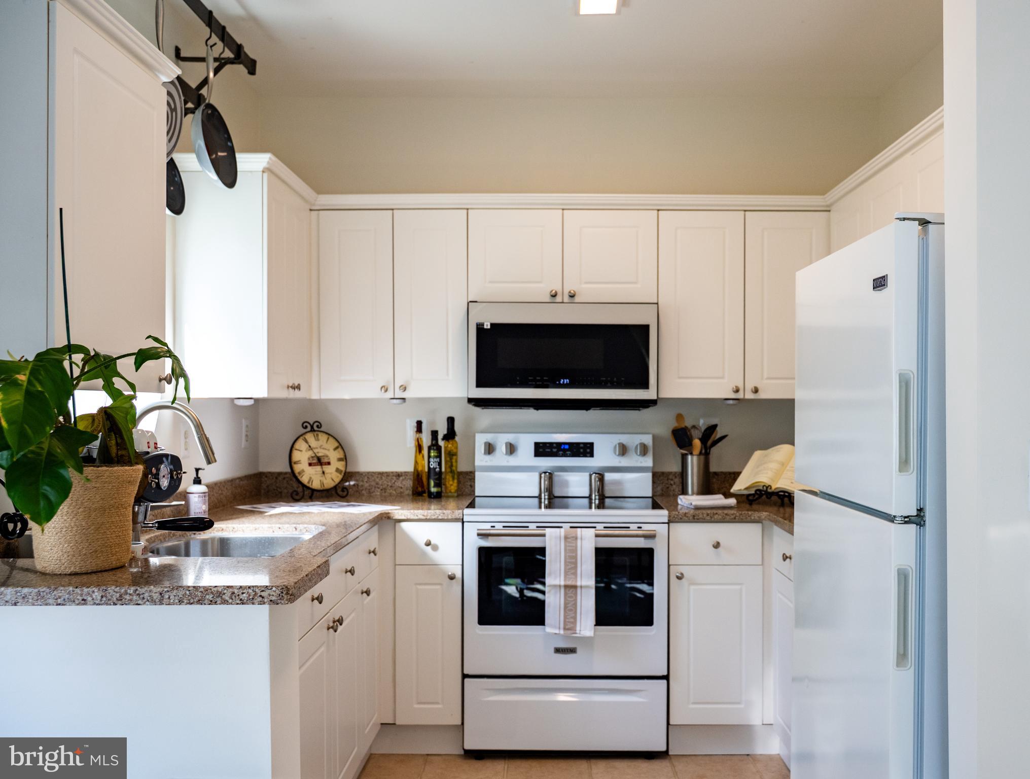 a kitchen with stainless steel appliances a stove refrigerator sink and cabinets