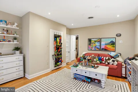 a living room with toys and dresser with wooden floor