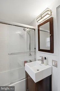 a bathroom with a sink a mirror and a shower
