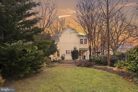 a view of house with yard and trees in the background