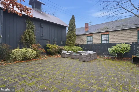 a view of a backyard with plants and a bench