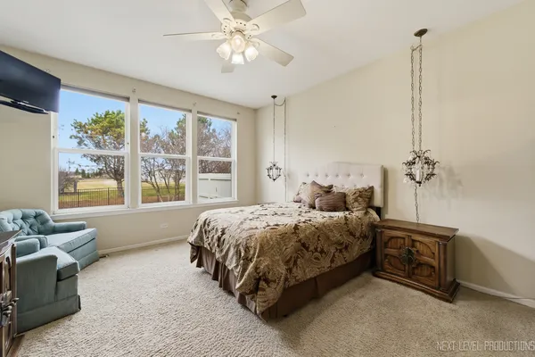 a spacious bedroom with a bed and a chandelier