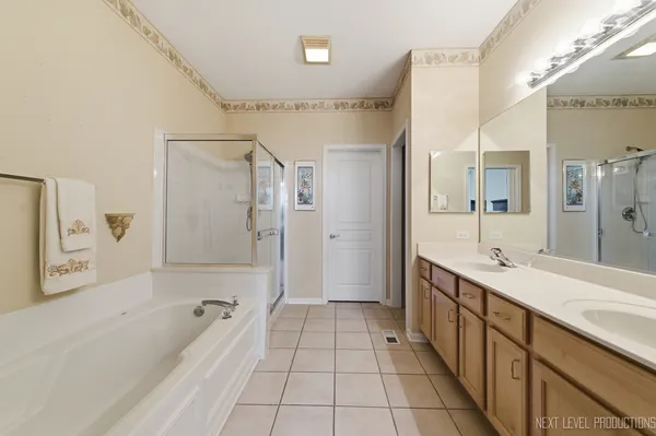 a spacious bathroom with a tub shower sink and mirror
