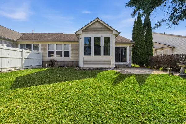 a front view of a house with a yard and potted plants