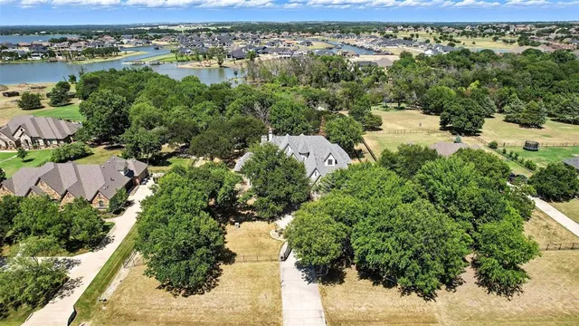 an aerial view of residential houses with outdoor space and lake view