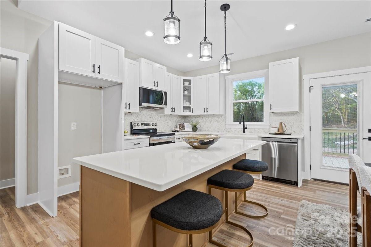 522 Waco Road Kings Mountain, NC 28086 - Photo 6 of 26 a kitchen with stainless steel appliances a stove a sink a refrigerator a dining table and chairs