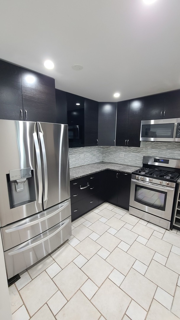 7548 Clarendon Hills Road, Unit 1B Willowbrook, IL 60527 - Photo 14 of 33 a kitchen with granite countertop a sink and stainless steel appliances
