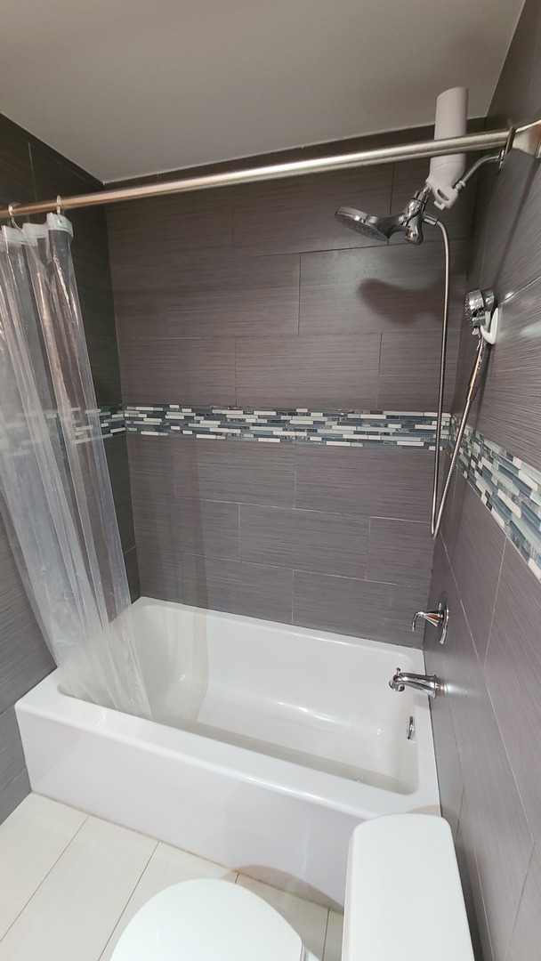 7548 Clarendon Hills Road, Unit 1B Willowbrook, IL 60527 - Photo 16 of 33 a bathroom with a shower and toilet