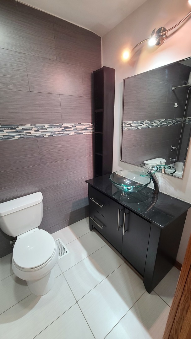 7548 Clarendon Hills Road, Unit 1B Willowbrook, IL 60527 - Photo 17 of 33 a bathroom with a toilet sink and mirror