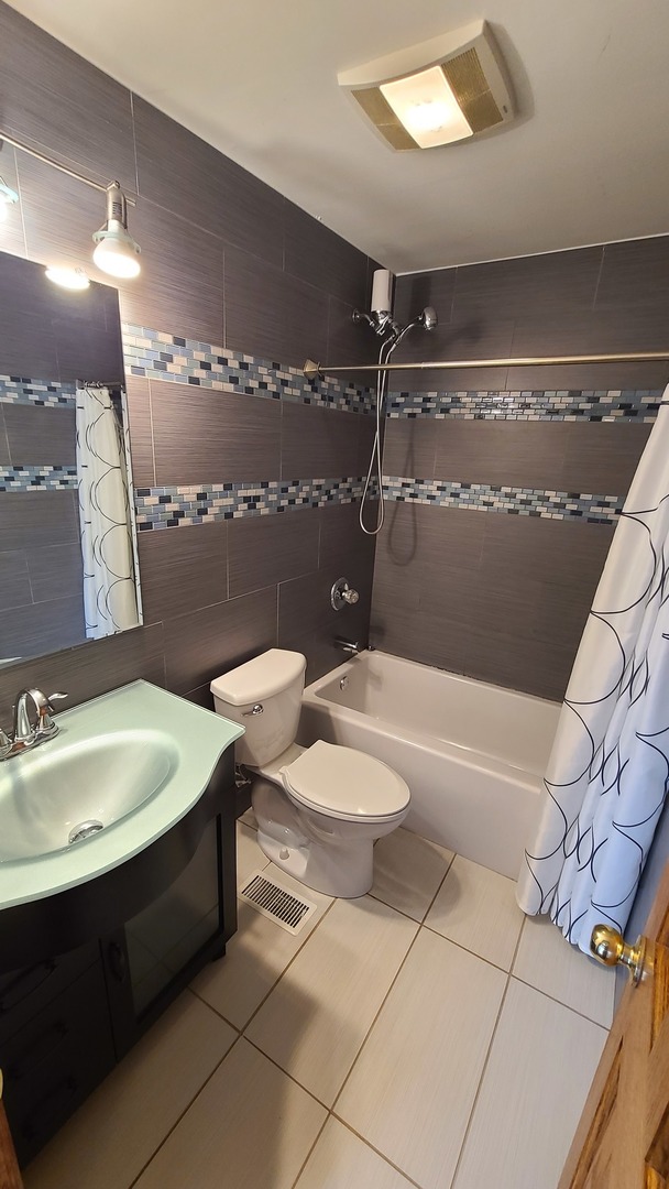 7548 Clarendon Hills Road, Unit 1B Willowbrook, IL 60527 - Photo 25 of 33 a bathroom with a sink a toilet a mirror and bathtub