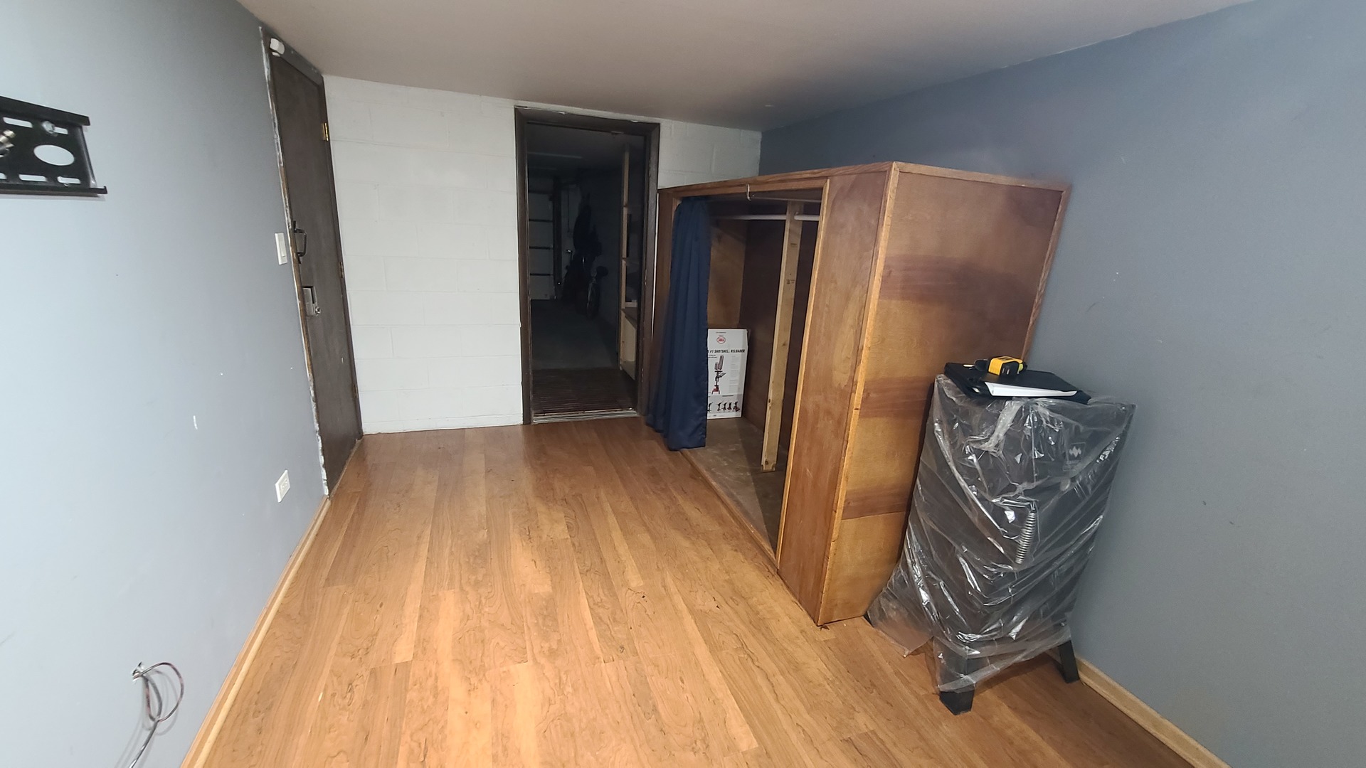 7548 Clarendon Hills Road, Unit 1B Willowbrook, IL 60527 - Photo 28 of 33 a view of a refrigerator in kitchen and an empty room with wooden floor