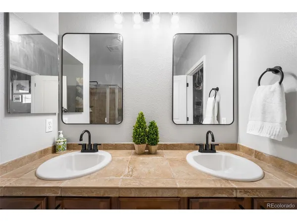a bathroom with double vanity sinks and a mirror