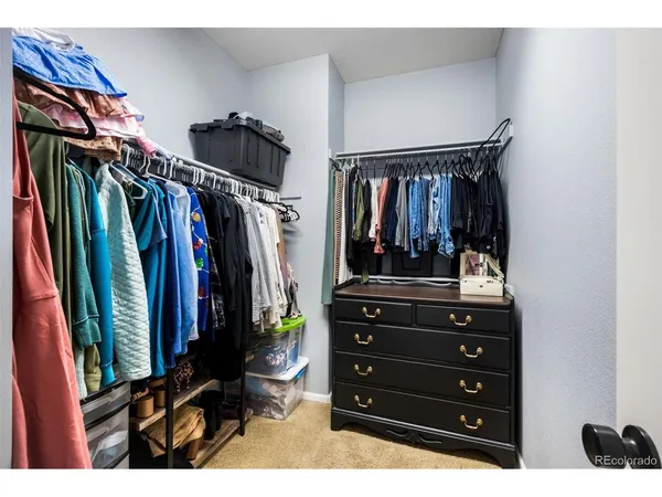 a view of walk in closet with clothes and shoes